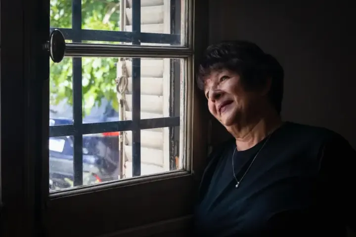 Senhora sorrindo perto da janela